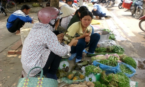 Người bán hàng ăn tạm miếng bánh ban trưa, cố bán hết hàng.