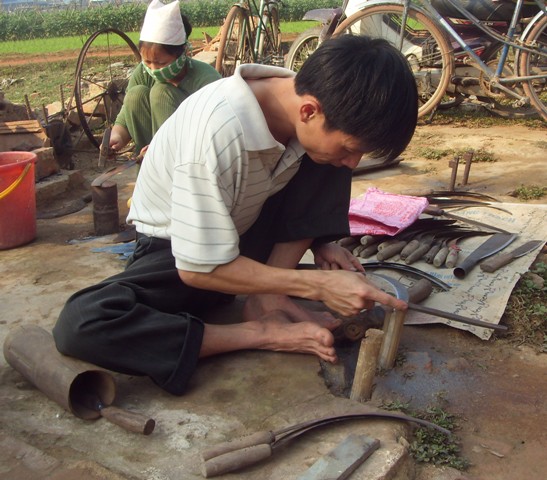 Anh thợ rèn tất bật với việc rèn lại liềm gặt lúa cho bà con quanh vùng.