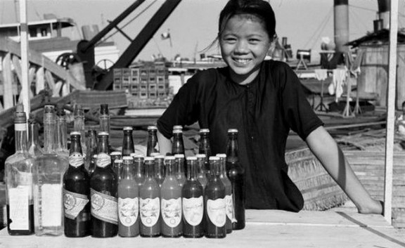Nụ cười hồn nhiên của cô bé bán nước bên bờ kênh.