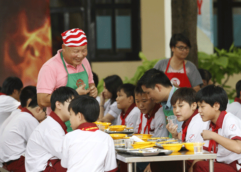 8 thí sinh chia làm hai đội nấu ăn cho khách mời là các em học sinh cấp 2. Ảnh: Ân Nguyễn.