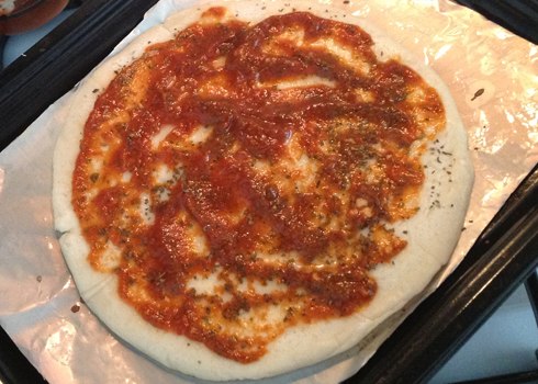 Thoa dầu đều lên mặt bánh, rắc lá basilic và sau cùng là nước sốt pizza sauce.