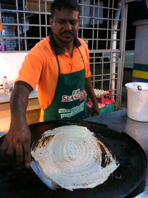 Một đầu bếp đang làm món Roti Canai - Ảnh: B.Giang